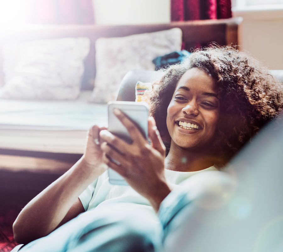 Woman looking a their phone and smiling